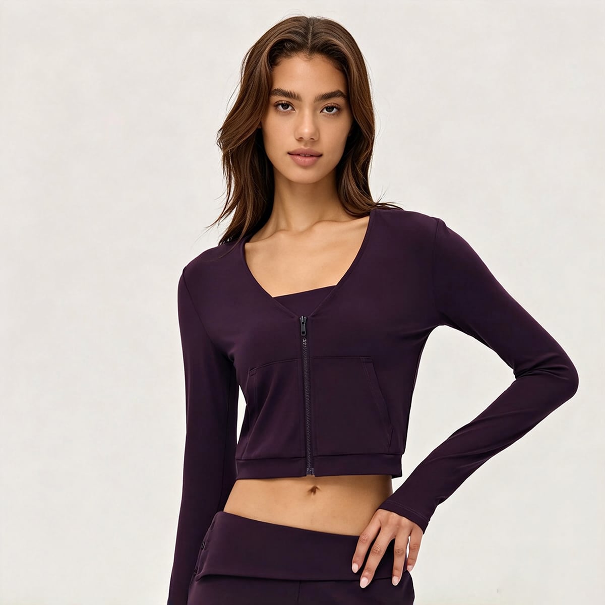 Front view of a deep plum purple V-neck cropped zip-up yoga jacket.