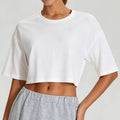 Front view of a crisp white loose-fit yoga crop tee for women, showcasing the breathable cotton-feel fabric.