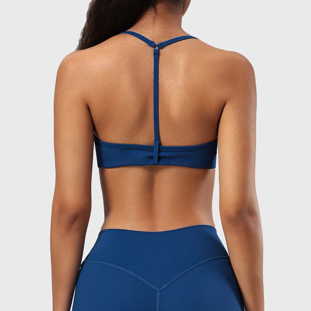 Back view showing skinny Y-back strap design on women's athletic bra in teal blue with custom logo, OEM gym wear manufacturer.