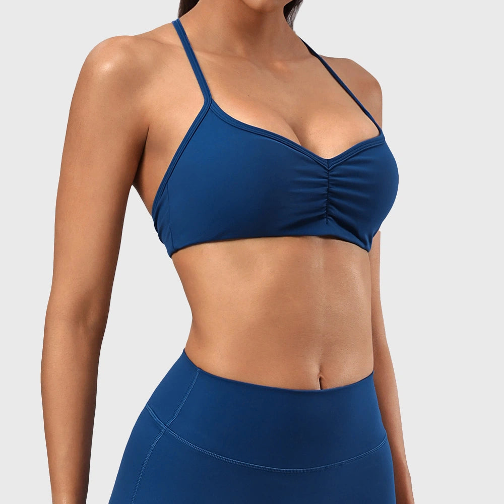 Side 3/4 view of women's spaghetti strap fitness sports bra in teal blue with custom logo, fitness clothing manufacturer.